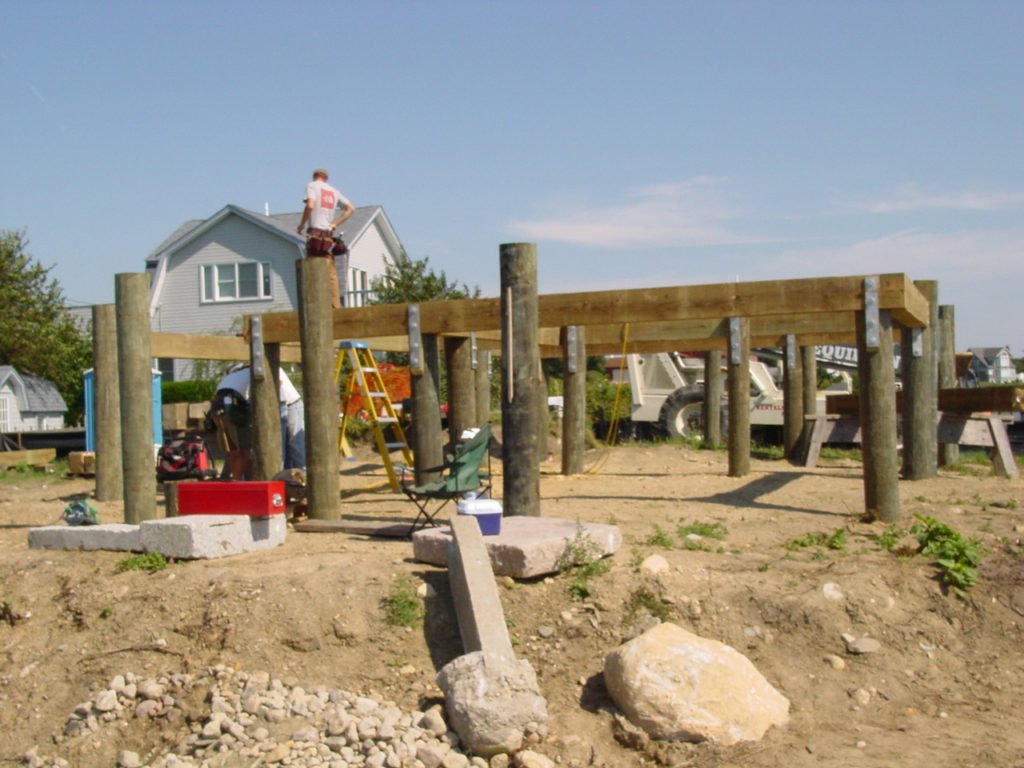 Large pressure treated timbers attached to pilings